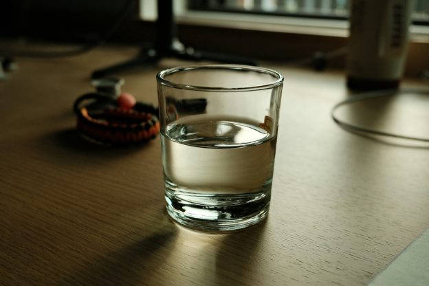 A glass of water on a wooden desk
